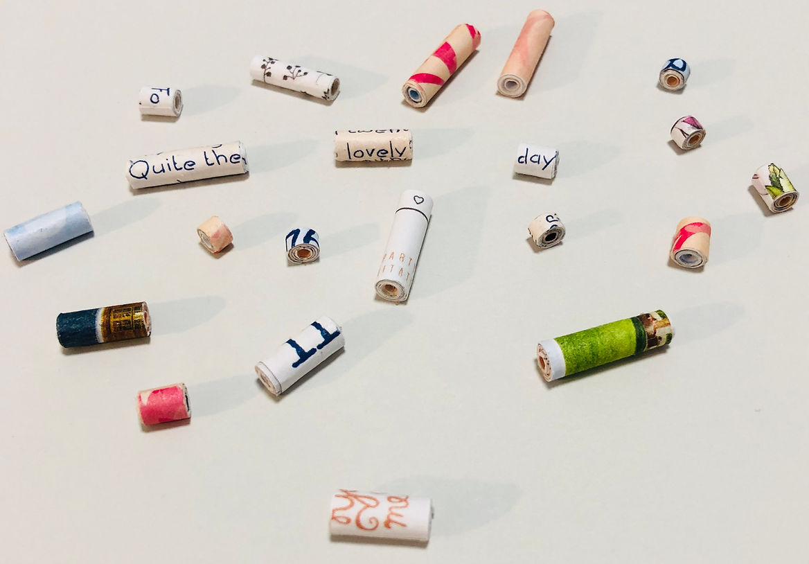 Hand-rolled paper tube beads made from colorful magazine pages